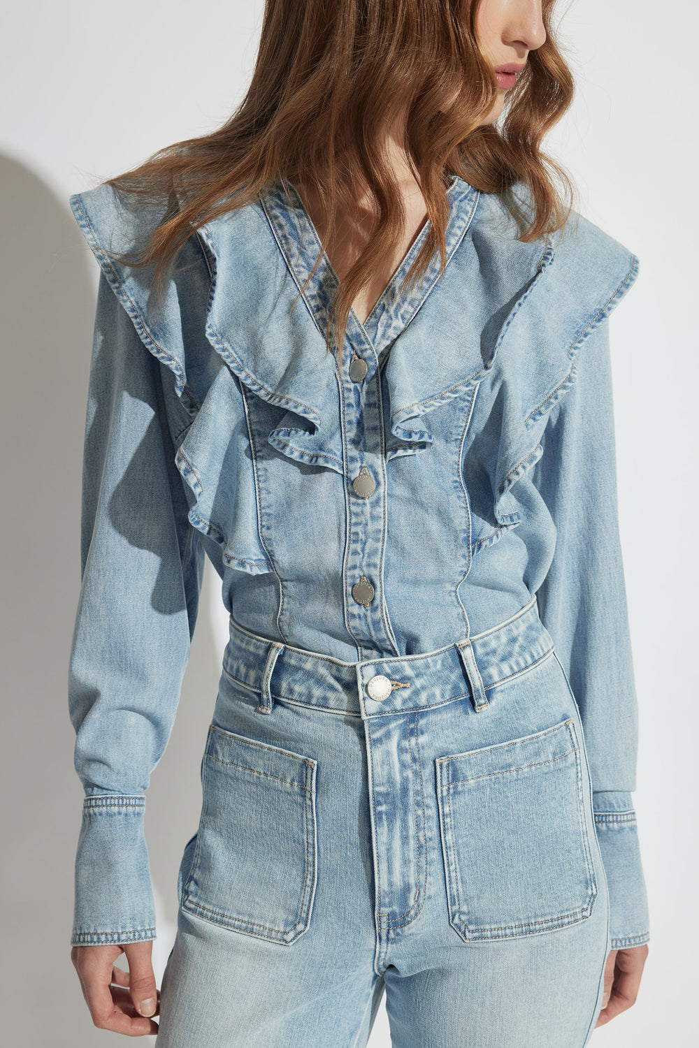 Model wearing Cecilia Ruffle Denim Blouse with button through front and ruffle detail, gallery position 2 portrait shot