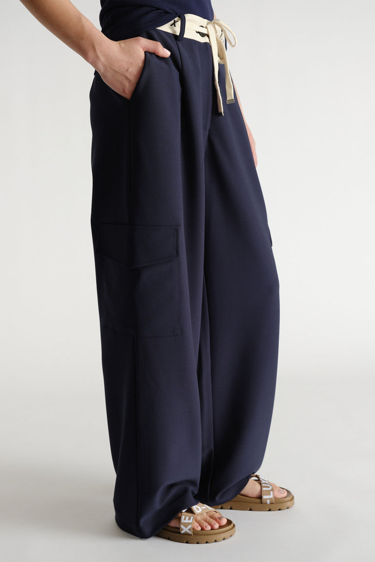 Navy wide-leg pants with contrast logo waistband and side cargo pockets styled with flat logo sandals