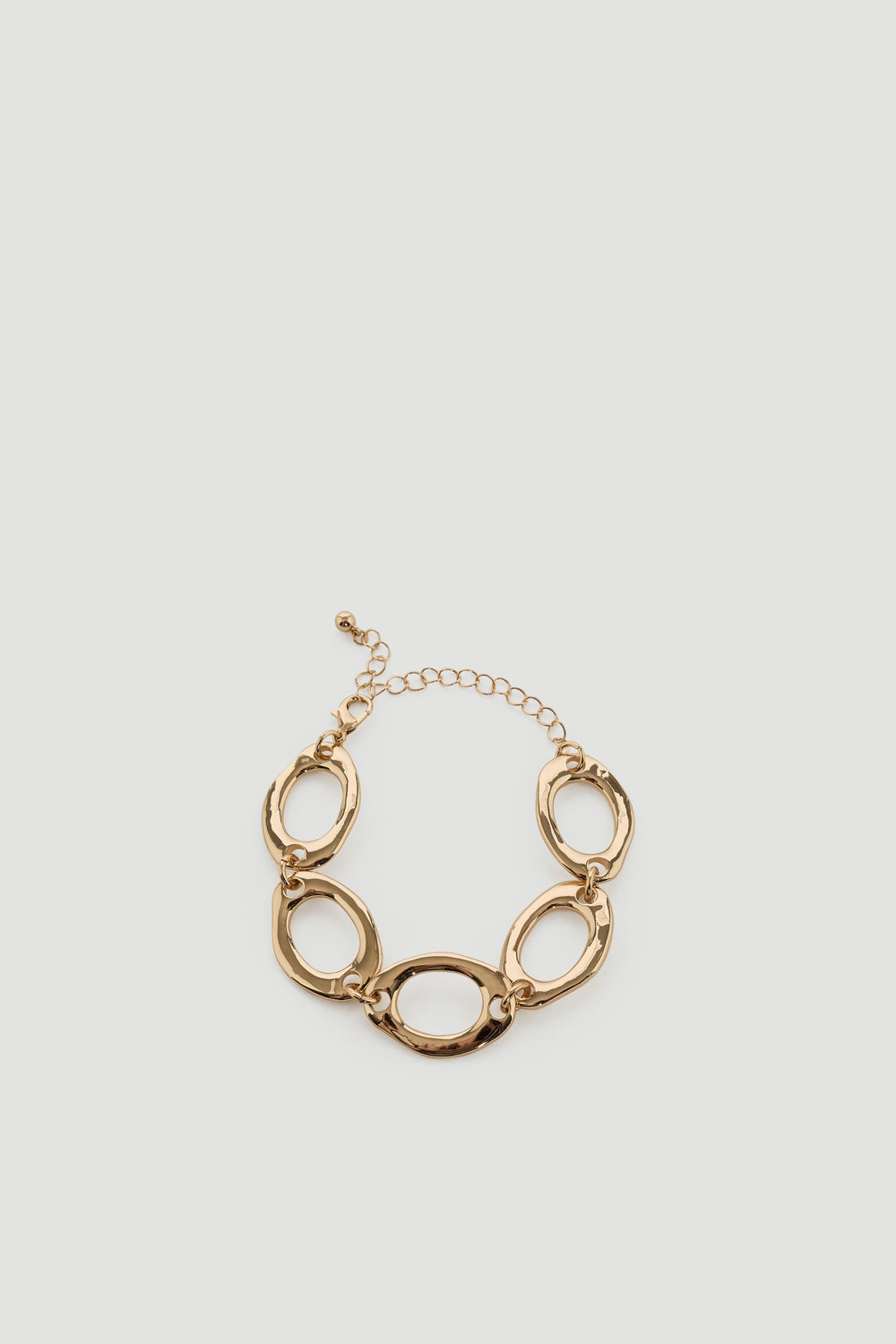 Gold-tone open chain bracelet with irregular oval links and adjustable clasp for versatile styling.