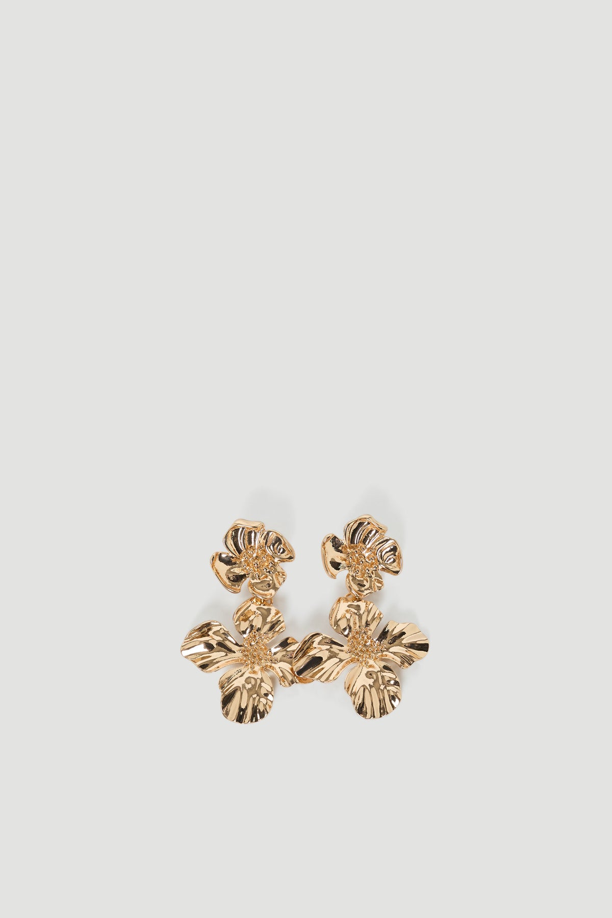 Gold-tone floral drop earrings with textured petals creating a delicate, elegant statement accessory.