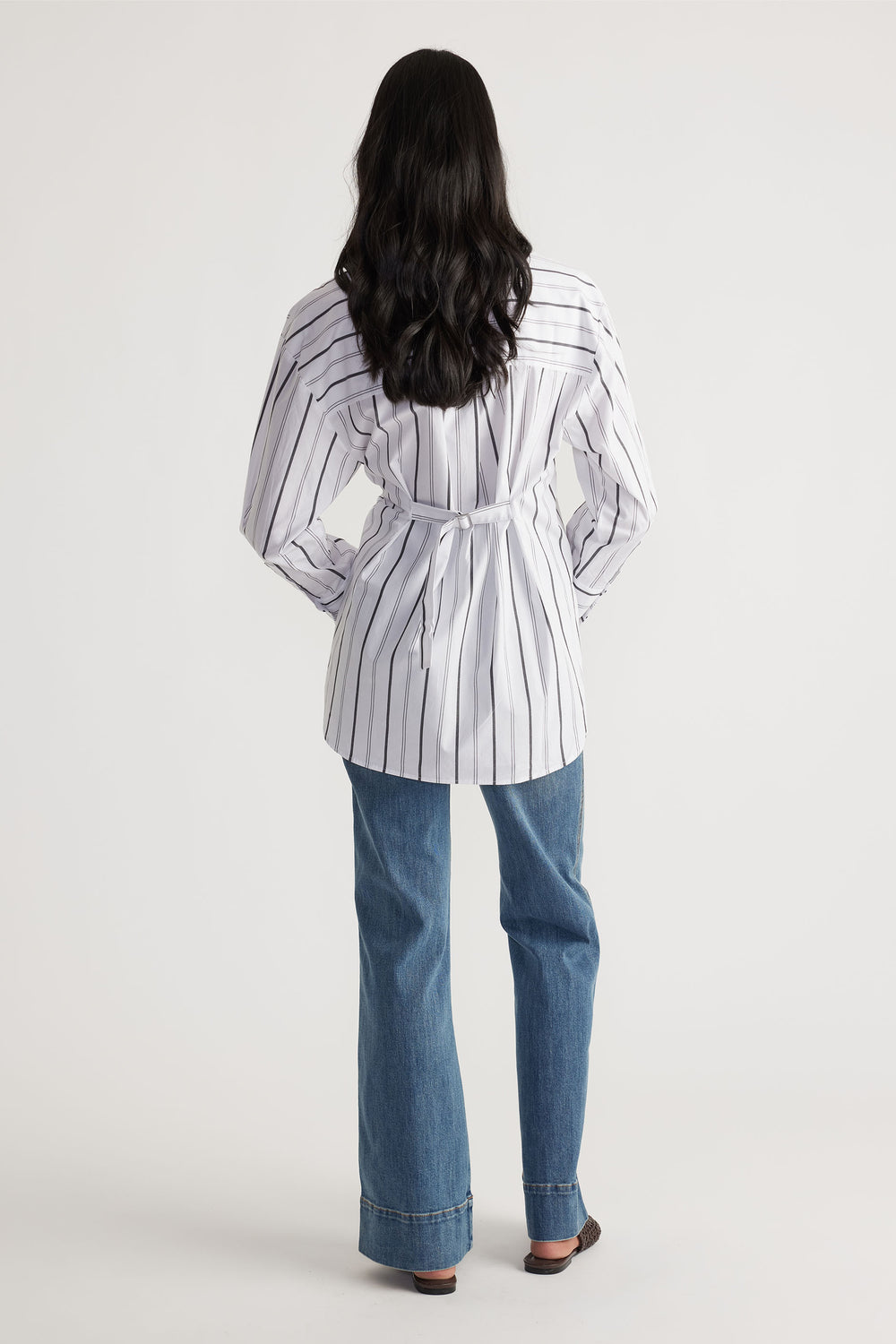 Rear view of model wearing Ivy Button Shirt with stripe pattern, back buckle strap, and relaxed fit in gallery position 3 portrait shot