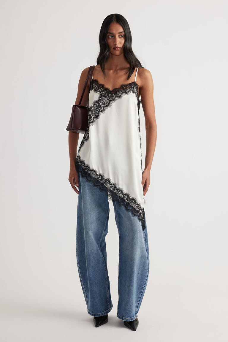 Model wearing Karla Lace Tunic with V neckline, lace trim, adjustable straps, and asymmetric hem in gallery position 1 portrait view.