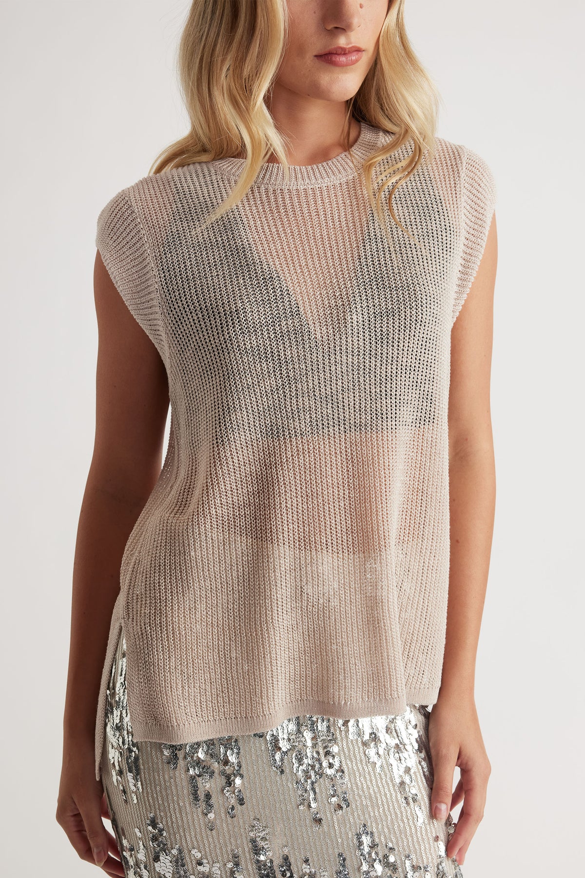 Lightweight beige knit tank with a relaxed fit, paired with a silver sequin skirt for a chic layered look