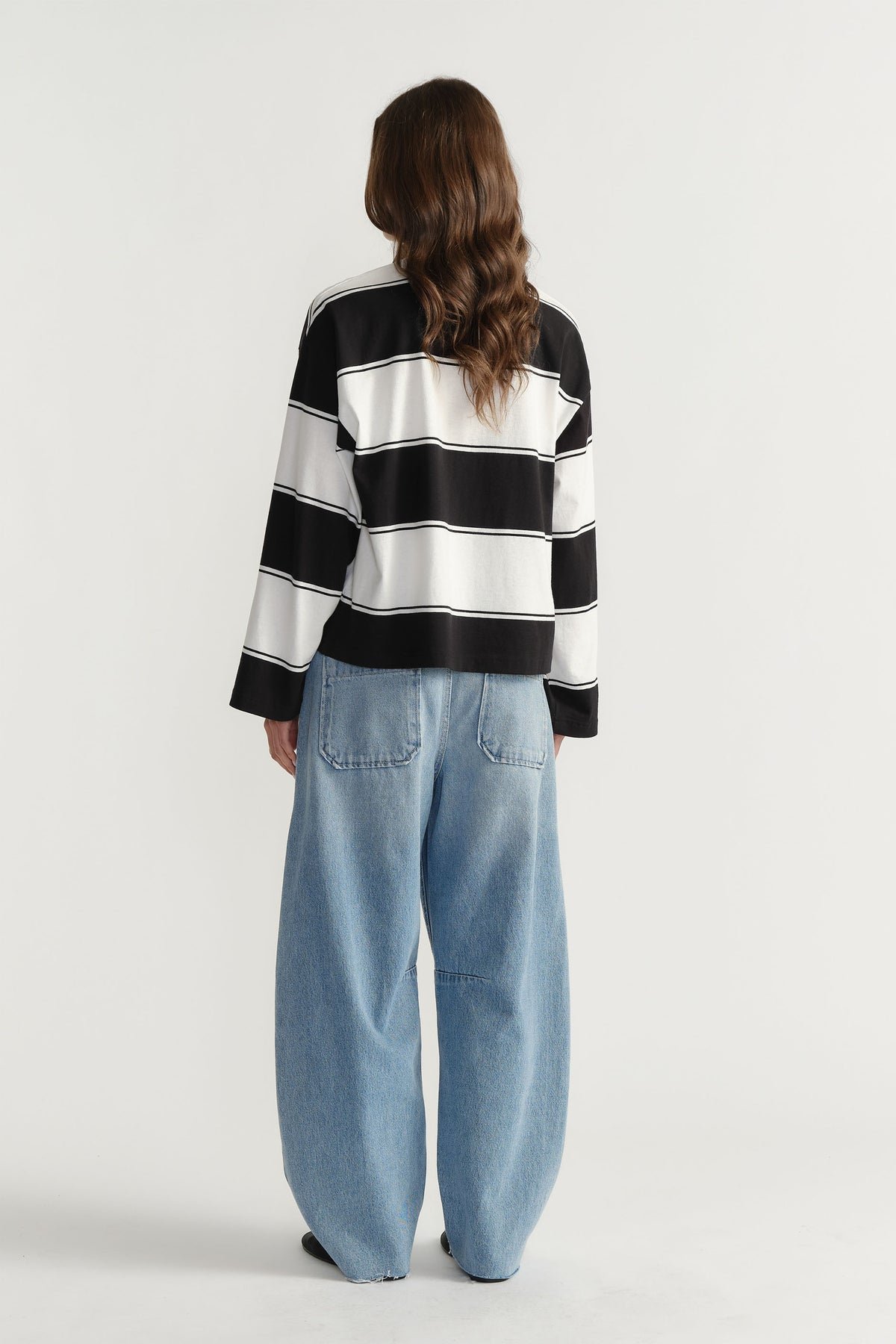 Back view of woman wearing D-Luxe Stripe Polo in 100% cotton with bold black and white stripes by DECJUBA Australian fashion brand