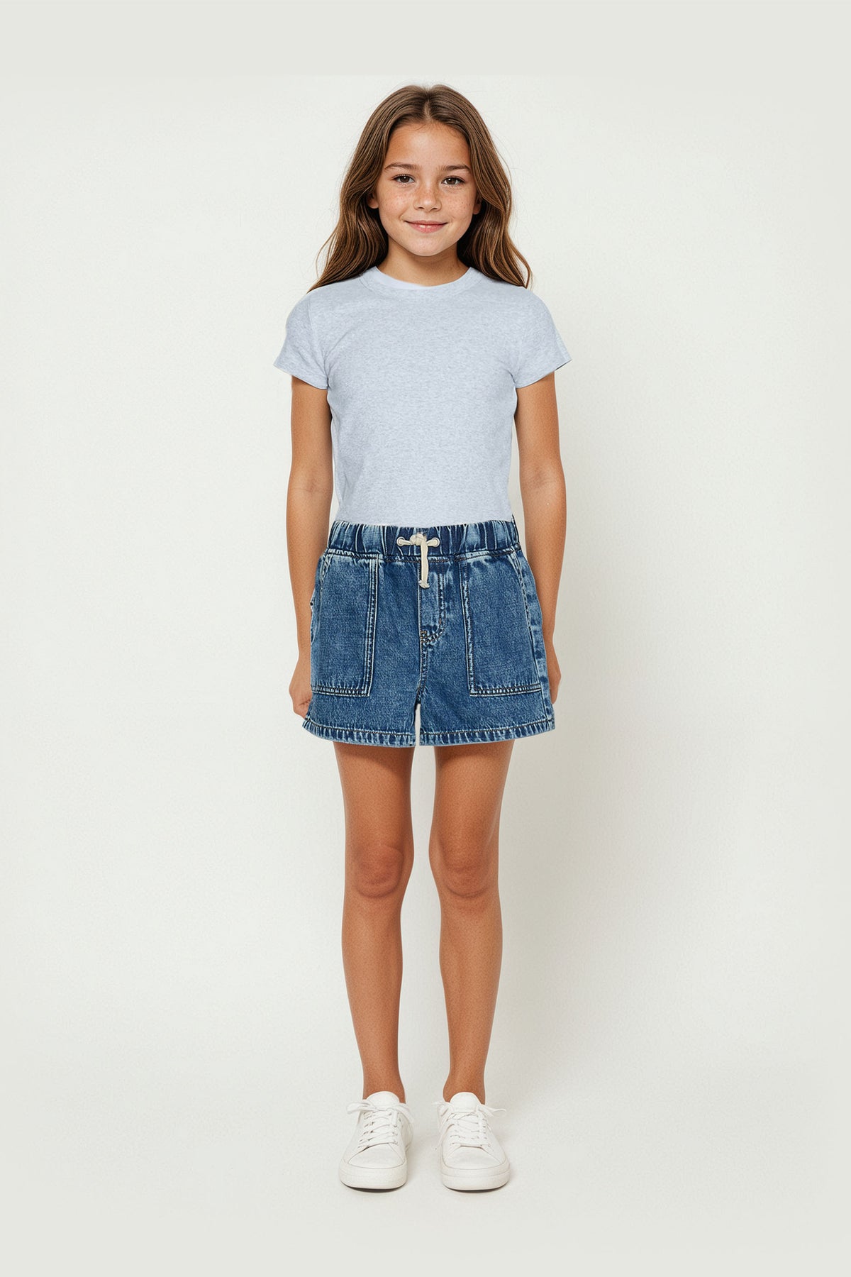 Girl wearing a light grey crop tee paired with a casual denim skirt and white sneakers for everyday comfort.