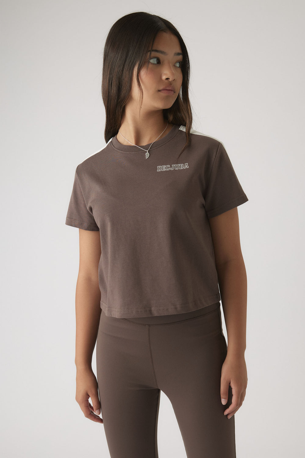 Girl wearing a relaxed mocha brown boxy tee with subtle logo and matching fitted pants for casual everyday style