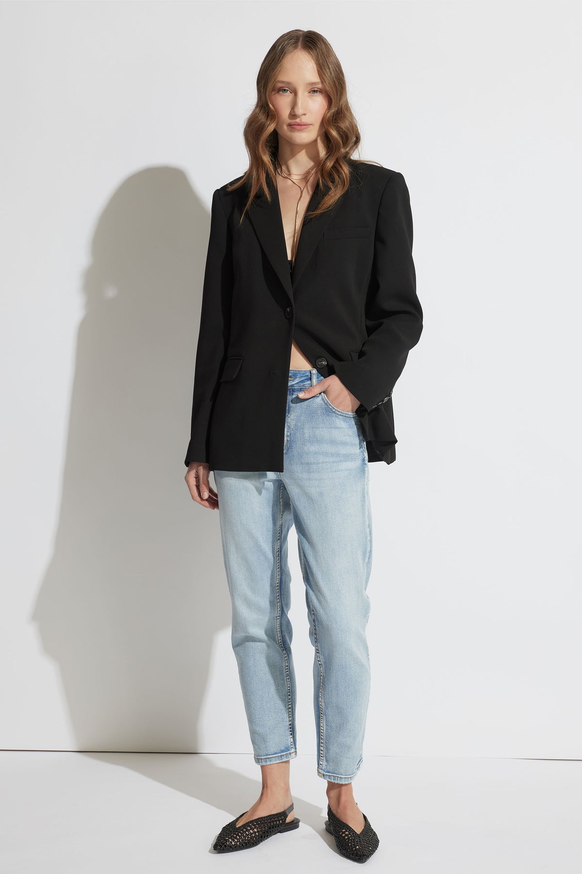 Woman wearing Alexa Girlfriend Jean in light denim with cropped slim leg and mid-rise waist, gallery image one portrait view