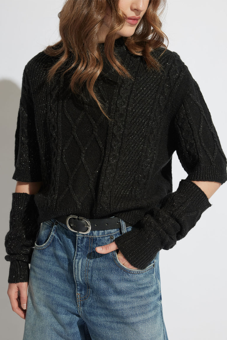 Sasha Lurex Cable Knit Jumper with detachable sleeves, worn two ways, styled with casual blue jeans in portrait view.