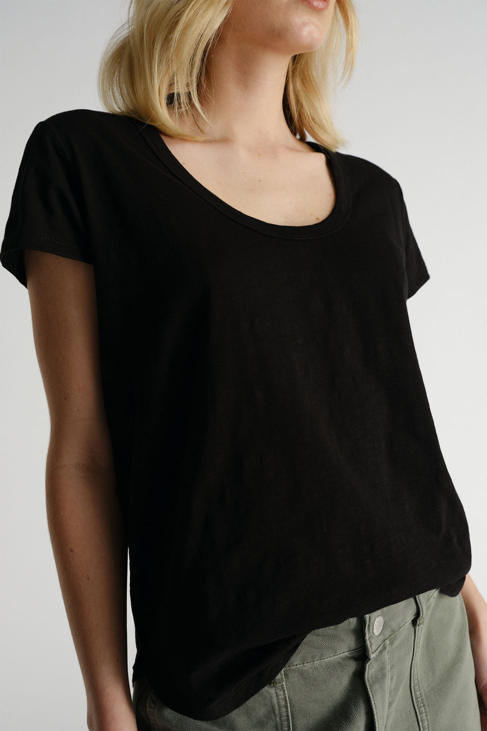 Woman wearing black D-Luxe Slub Tee paired with olive pants, showcasing versatile style by Decjuba Australian fashion brand