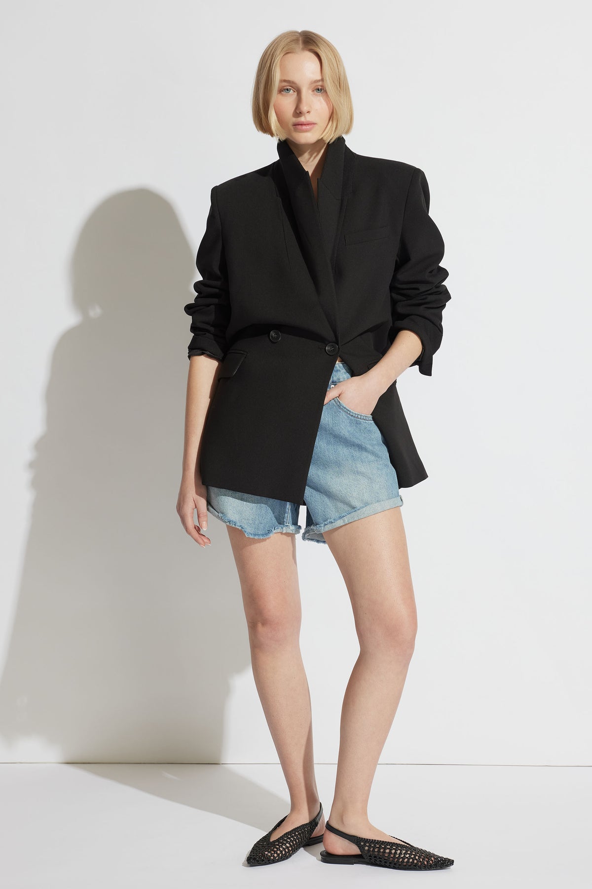 Model wearing Harper Rolled Cuff Denim Short with a black oversized blazer, portrait, gallery position 1, 1880x2820px