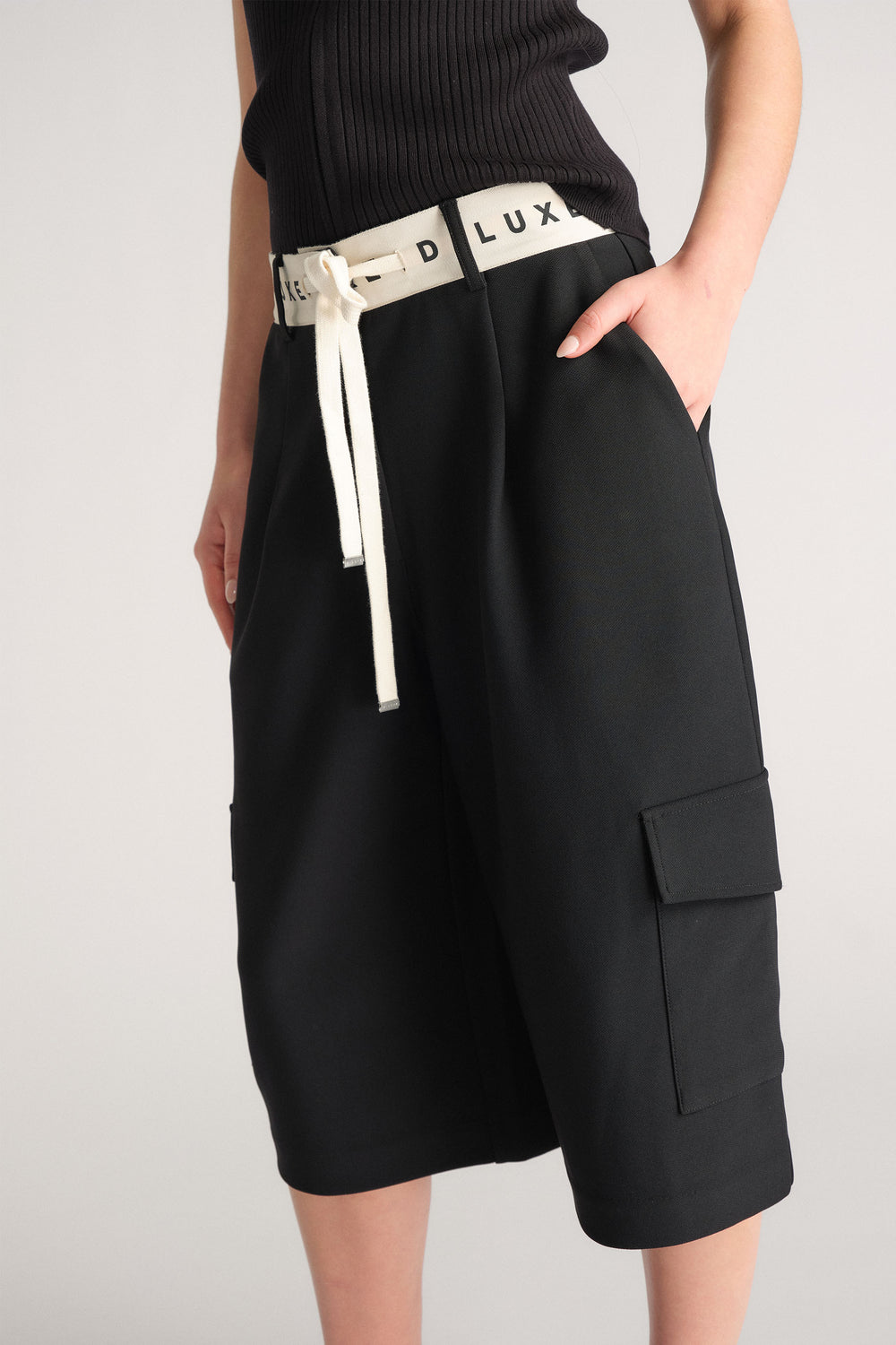 D-Luxe Logo Waistband Short in black with contrast logo waistband, cargo pocket details, worn with hand in pocket, gallery 2 portrait view