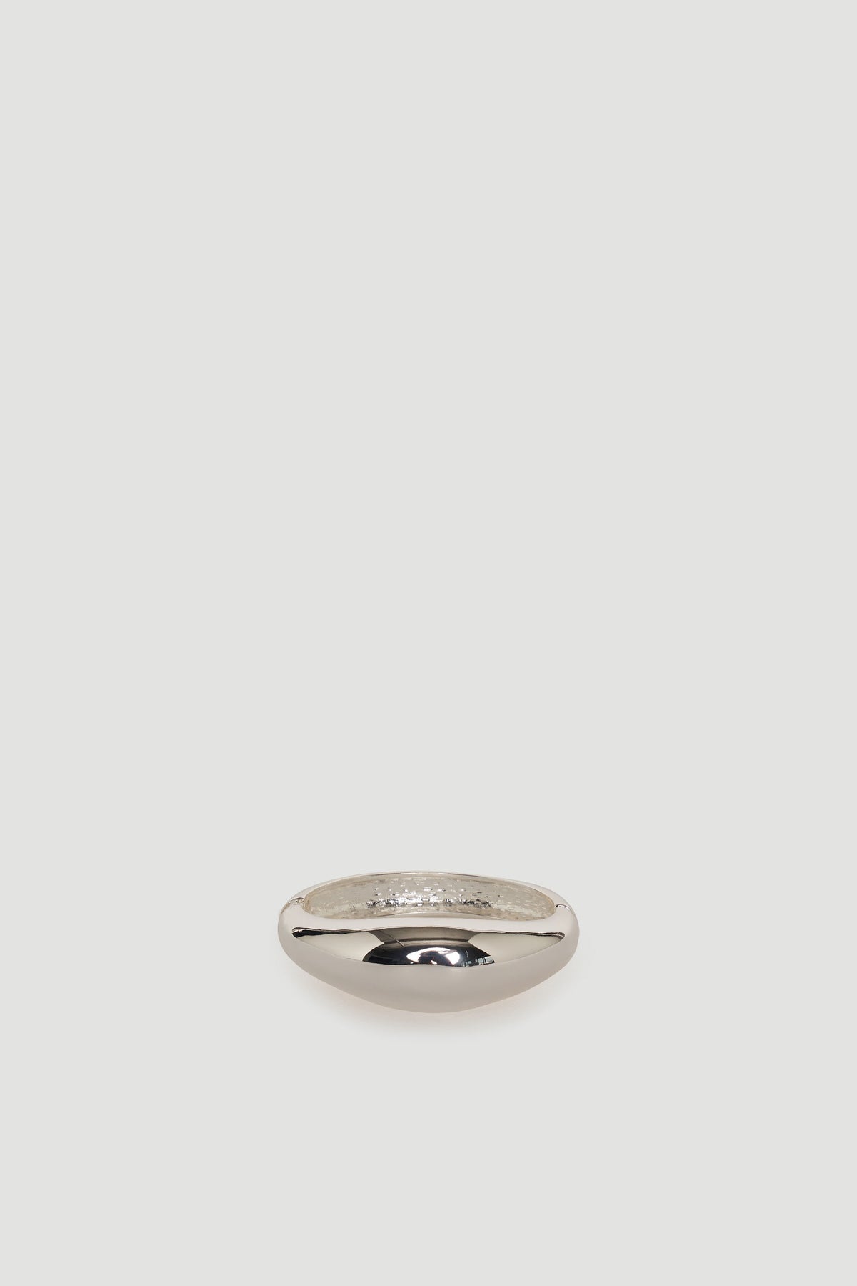 Smooth silver-tone bangle with a polished finish, showcasing a simple and elegant rounded design.