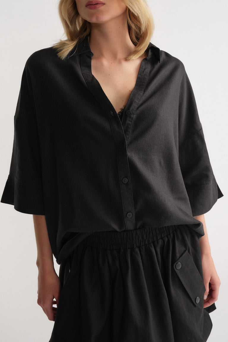 Model wearing black D-Luxe Linen Blend 3/4 Shirt in gallery position 2, portrait, soft breathable linen blend fabric.