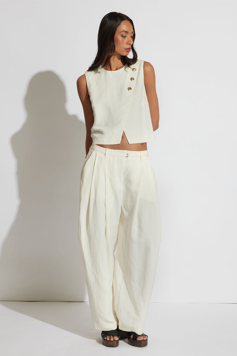 Model in portrait wearing white Leah Linen Blend Pant with pleated barrel leg, styled with matching sleeveless top, gallery 1 view