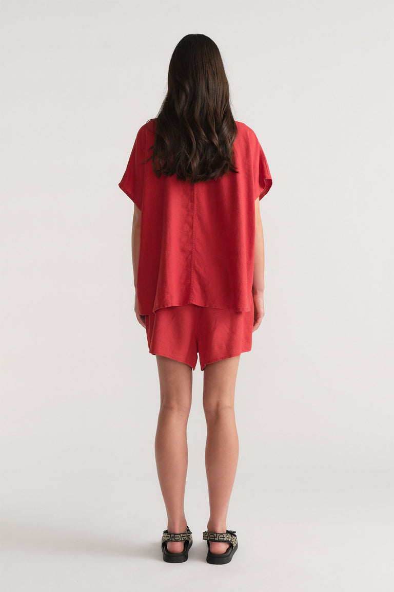 Back view of model wearing red D-Luxe Linen Blend Flip Short in gallery position 3, portrait orientation 1880x2820.