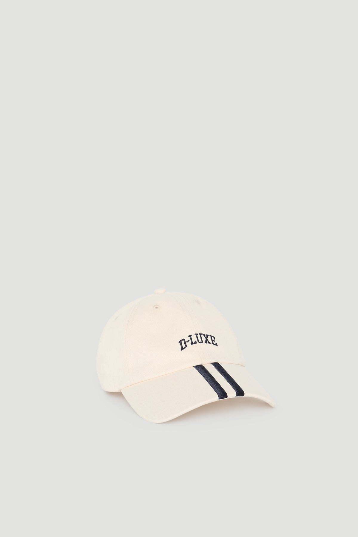 Cream-coloured cap with sporty navy stripes on the brim and subtle embroidered lettering for a casual look.