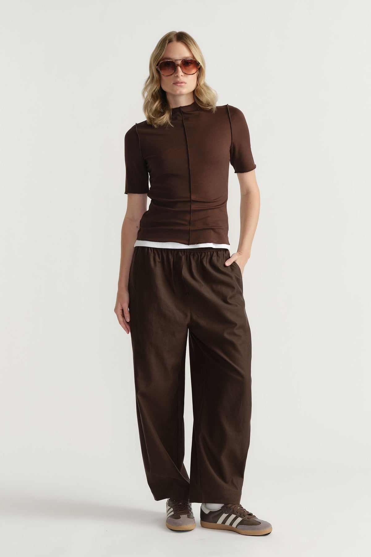 D-Luxe Short Sleeve Top in brown with mock neck and centre front seam worn with matching pants in portrait view.