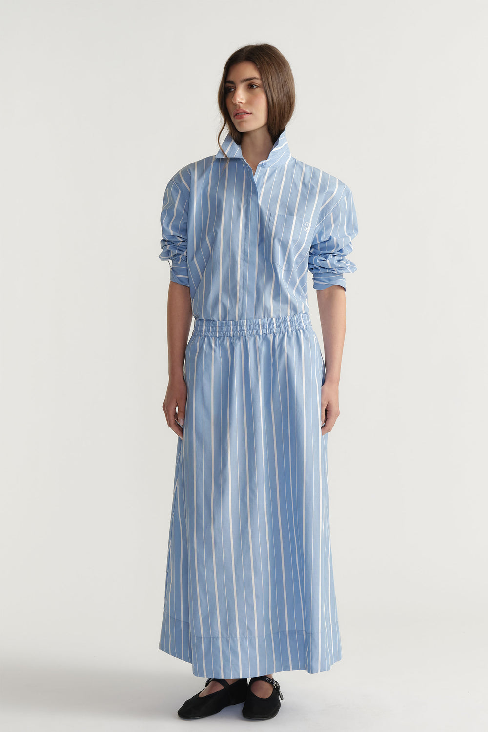 Woman wearing a blue and white striped D-Luxe Poplin Stripe Skirt with elasticated waistband, portrait orientation, gallery 1