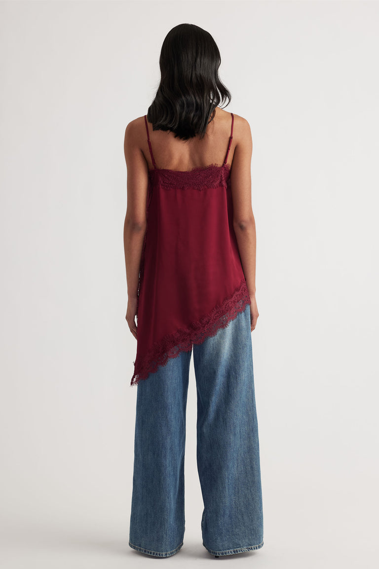 Woman seen from back wearing Karla Lace Tunic in deep red with lace trim and wide-leg denim pants by Decjuba Australian brand