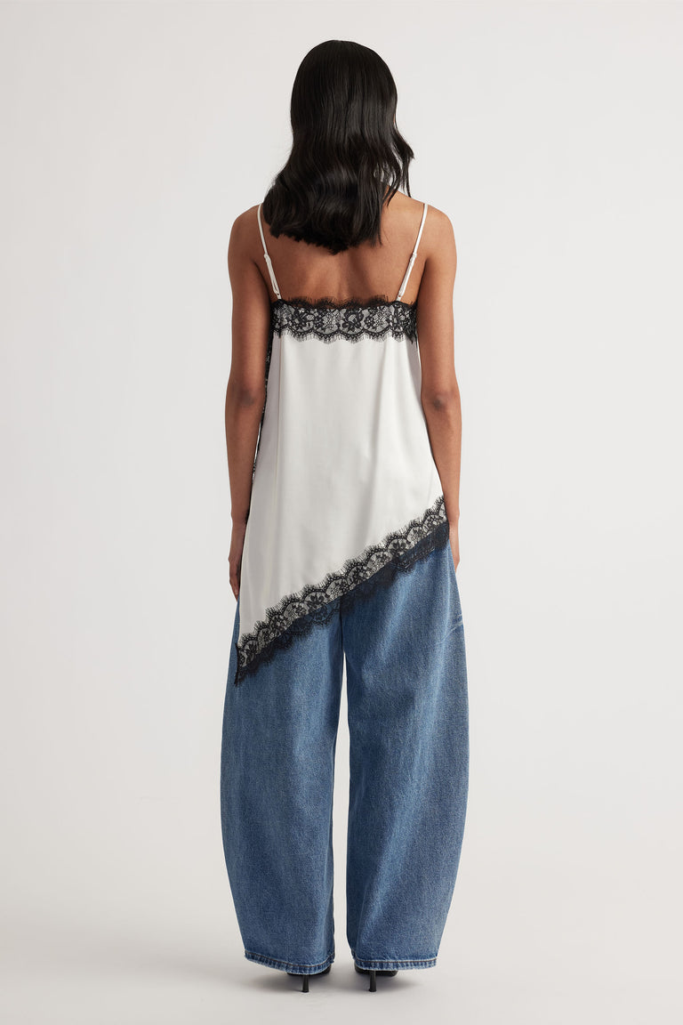 Back view of model wearing Karla Lace Tunic with black lace trim and asymmetric hem, paired with wide-leg denim jeans.