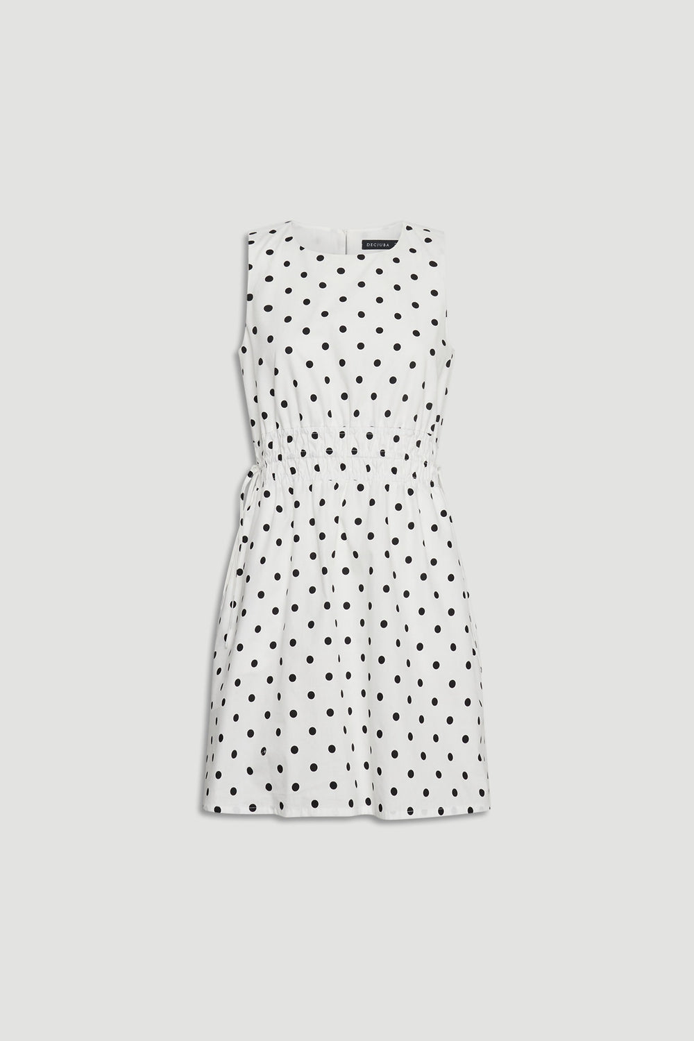 Cali Spot Mini Dress in portrait view showcasing sleeveless design with shirred waist and black polka dots on white fabric.
