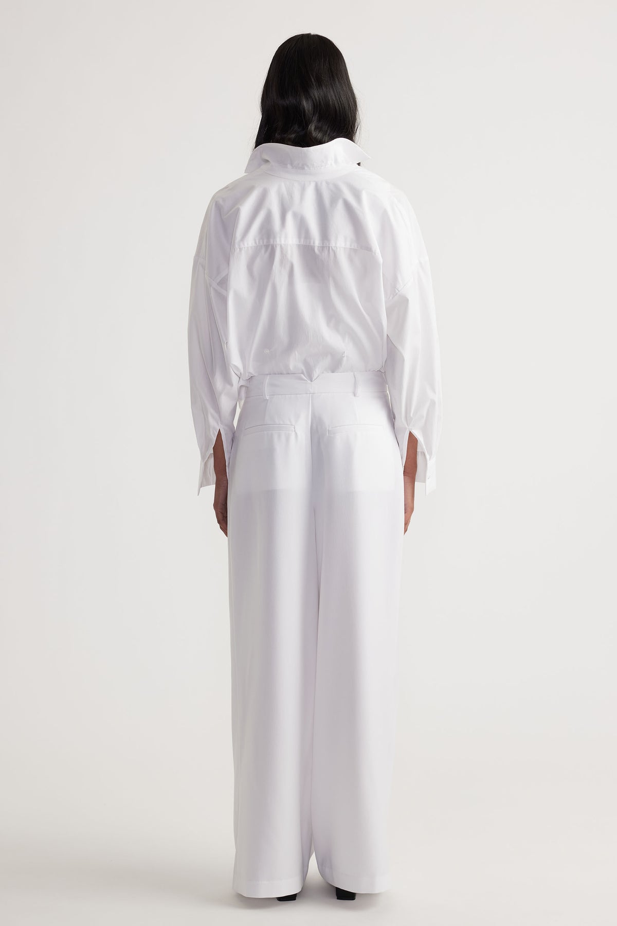 Clara Pleated Pant in white with wide-leg fit and high waist, styled from behind by DECJUBA Australian fashion brand