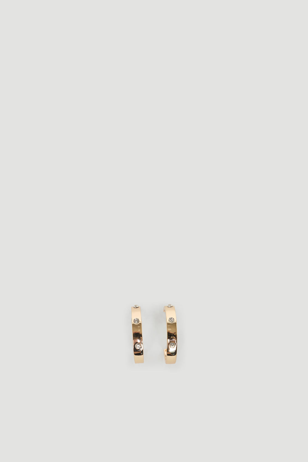 Elegant gold hoops accented with sparkling diamantes for a subtle and refined everyday accessory.