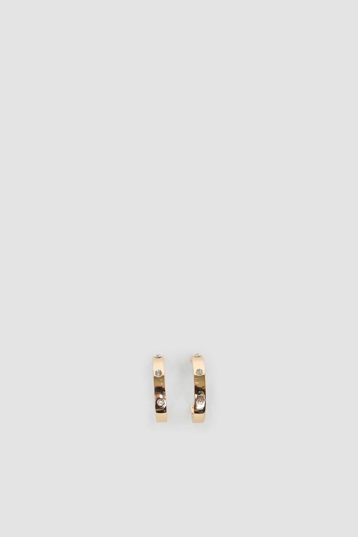 Elegant gold hoops accented with sparkling diamantes for a subtle and refined everyday accessory.
