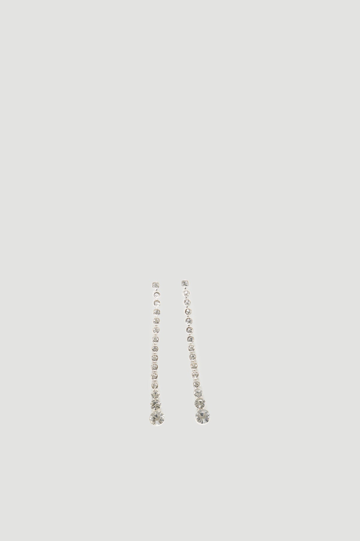 Delicate silver drop earrings featuring a vertical line of sparkling diamante stones with a larger gem at the base