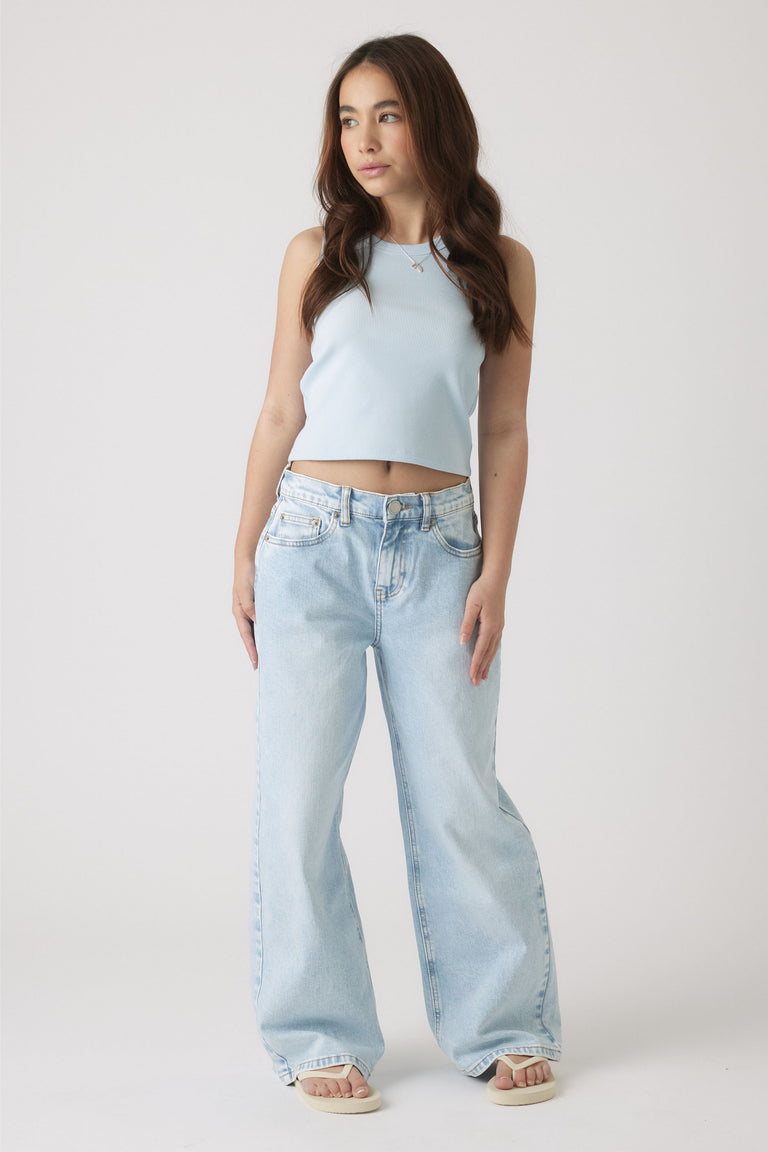 Girl wearing a pale blue sleeveless tank paired with relaxed light wash wide-leg jeans and sandals for casual style