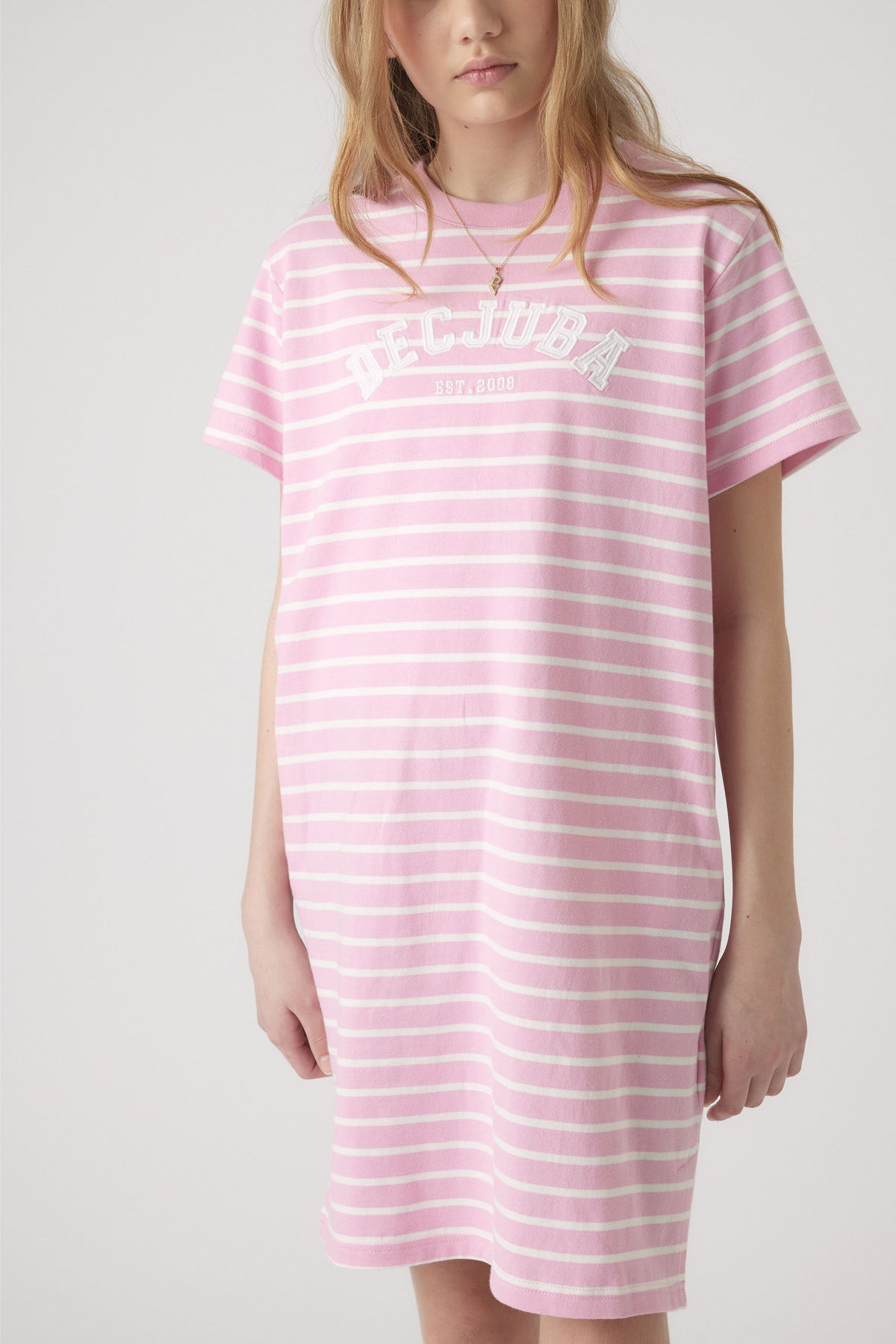 Girl wearing a relaxed pink and white striped rugby tee dress with short sleeves and casual fit