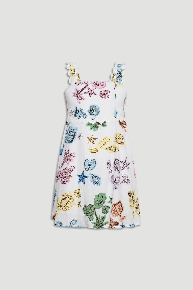 White girls dress with scalloped straps and colorful seashell and starfish illustrations throughout the fabric