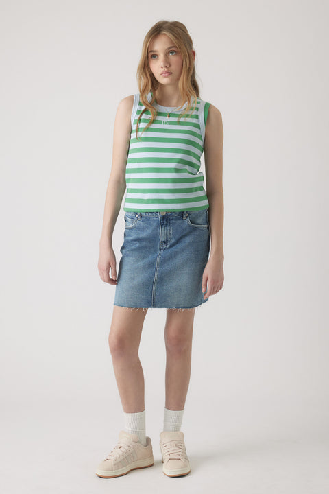 Girl wearing a green and white striped tank top paired with a casual blue denim skirt and cream sneakers