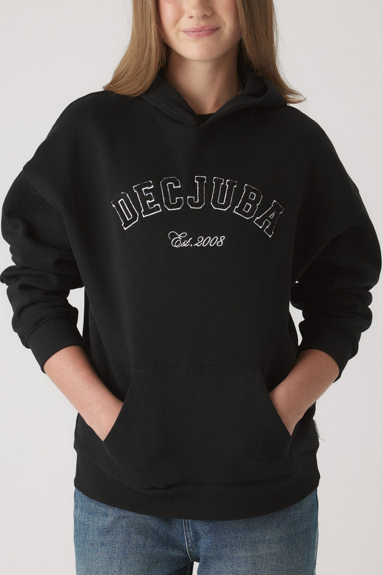 Girl wearing a relaxed black oversized hoodie with Decjuba logo and front pouch pocket paired with blue denim jeans