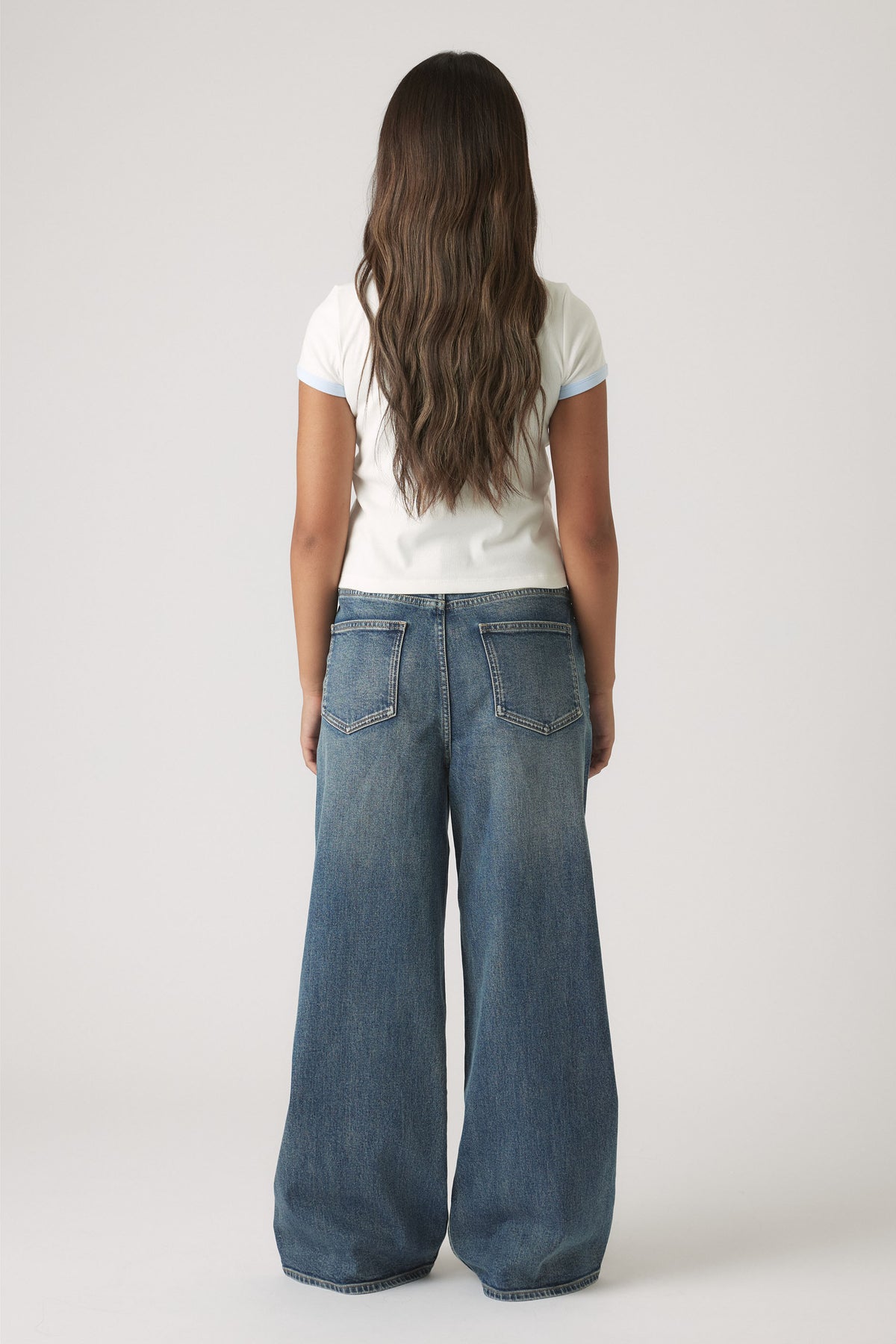 Girls Cropped Ringer Tee in white with light blue trim, styled with wide-leg denim jeans for a relaxed look by DECJUBA Australian brand
