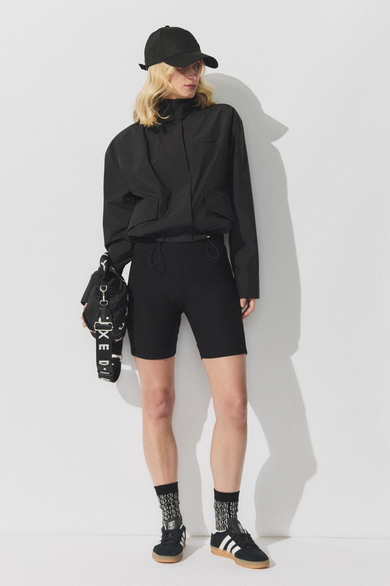 Portrait shot gallery 2 of D-Luxe Cropped Spray Jacket styled with black cap and shorts against white background