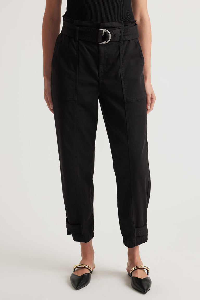 Front view of black high-waisted pull-on pants with belt and cuffed hems paired with pointed flats