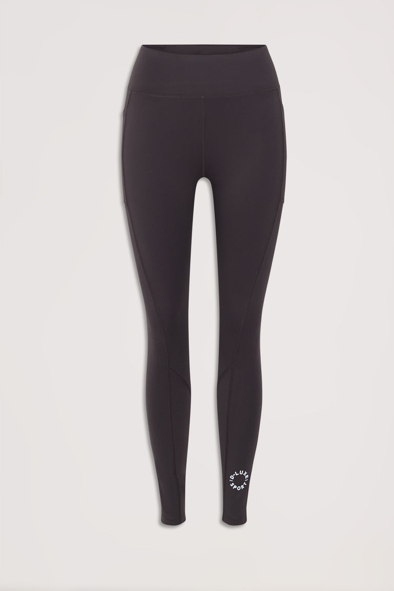 D-Luxe Stamp Legging front view in portrait with signature ankle branding and sleek mid-waisted fit, gallery position 4.