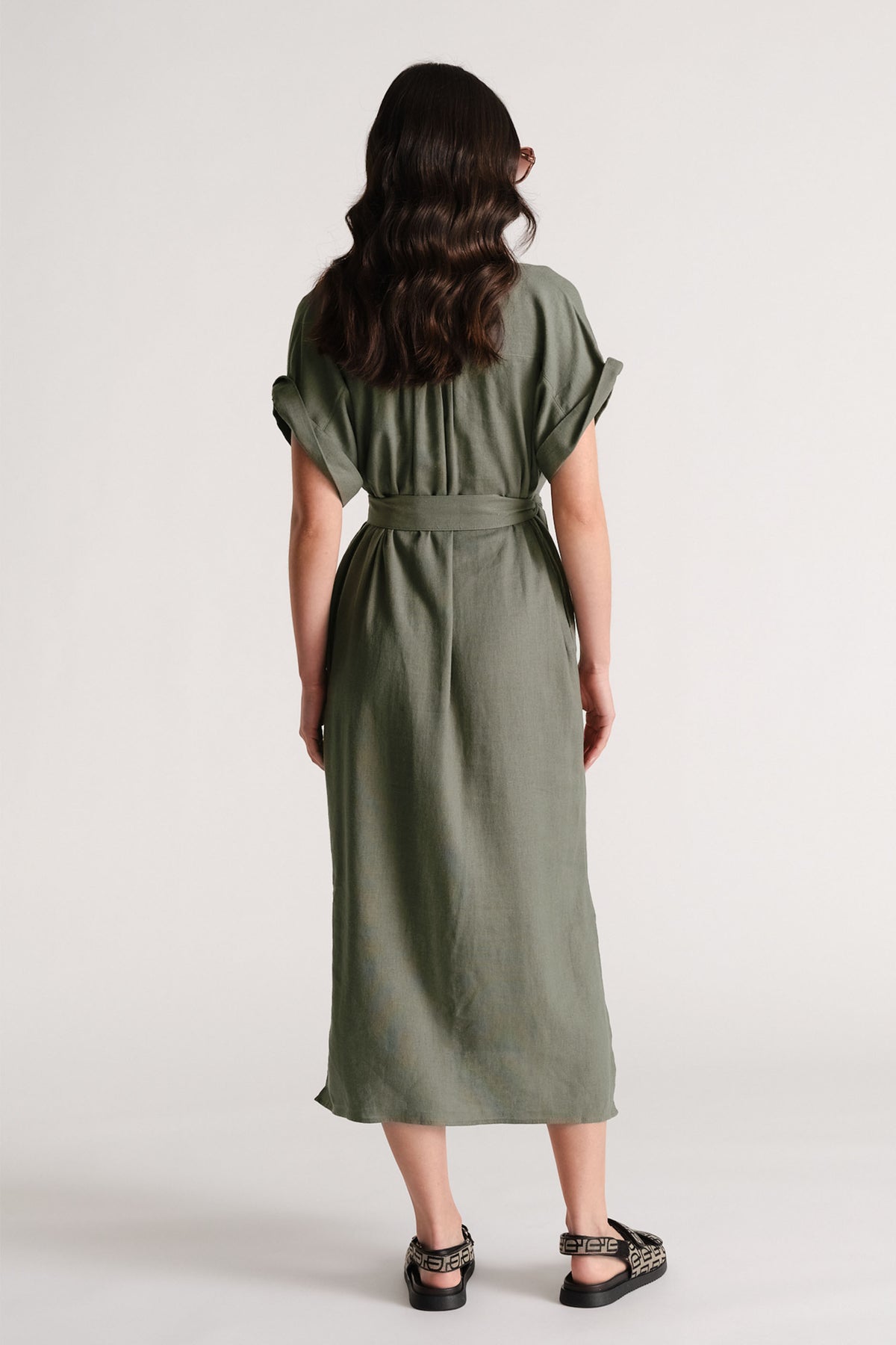 Back view of model in olive D-Luxe Linen Blend Midi Dress with rolled sleeves and waist tie, gallery position 3 portrait