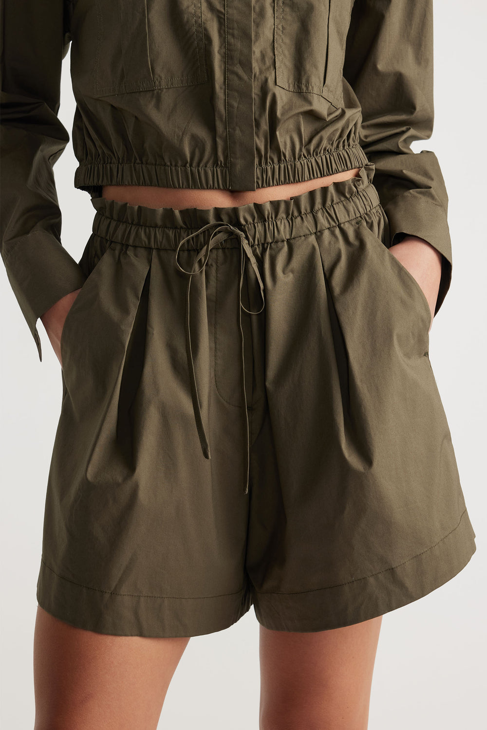 High-waisted olive green shorts with a gathered drawstring waist and side pockets for an easy, relaxed fit.