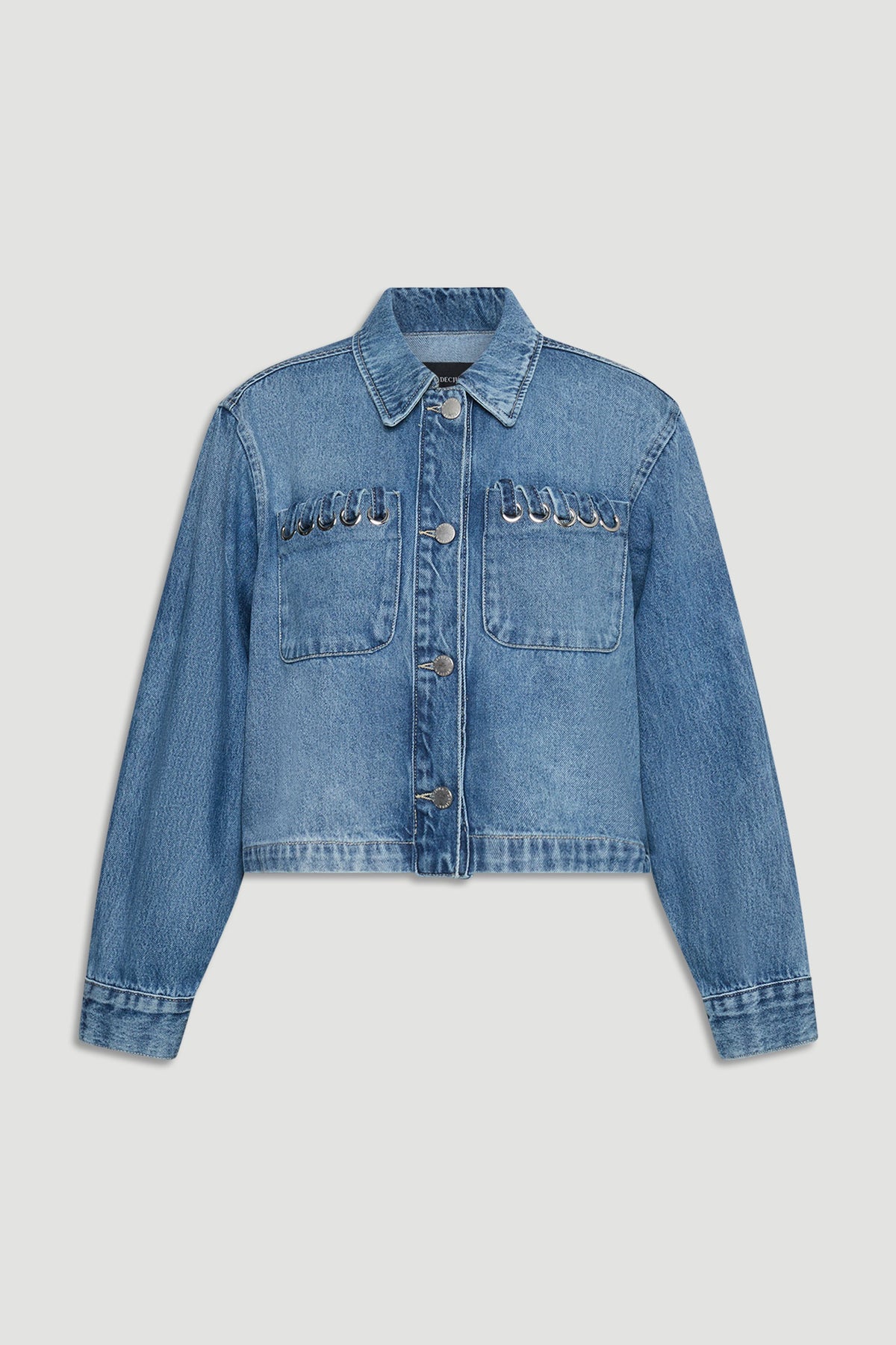 Cropped blue denim jacket with front pockets and silver ring details along the pocket seams for a modern touch.