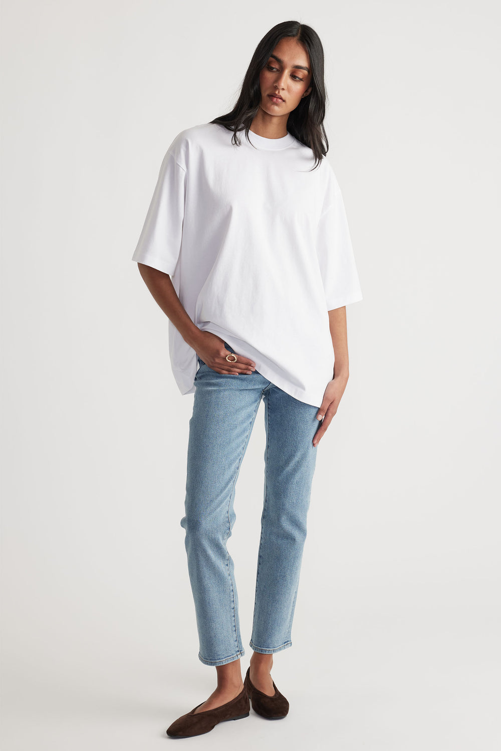 Woman styled in Becky Hemmed Straight Leg Jean in light denim paired with oversized white tee by Decjuba Australian fashion brand