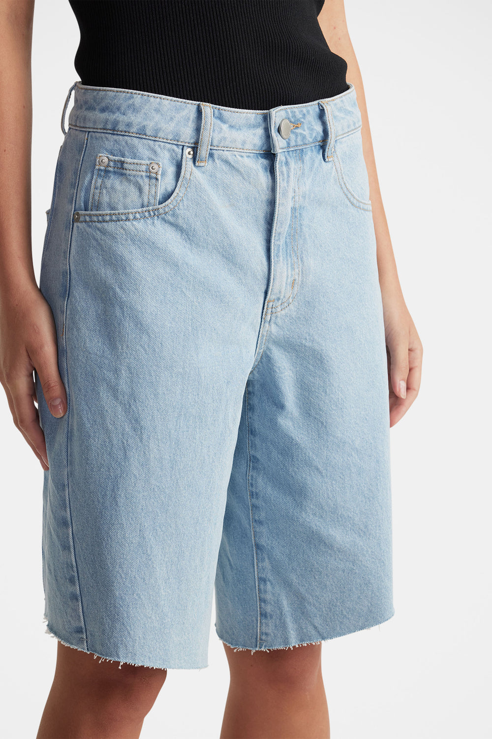 Light wash denim shorts with raw hem, mid-rise waist, and classic five-pocket design for casual, everyday style
