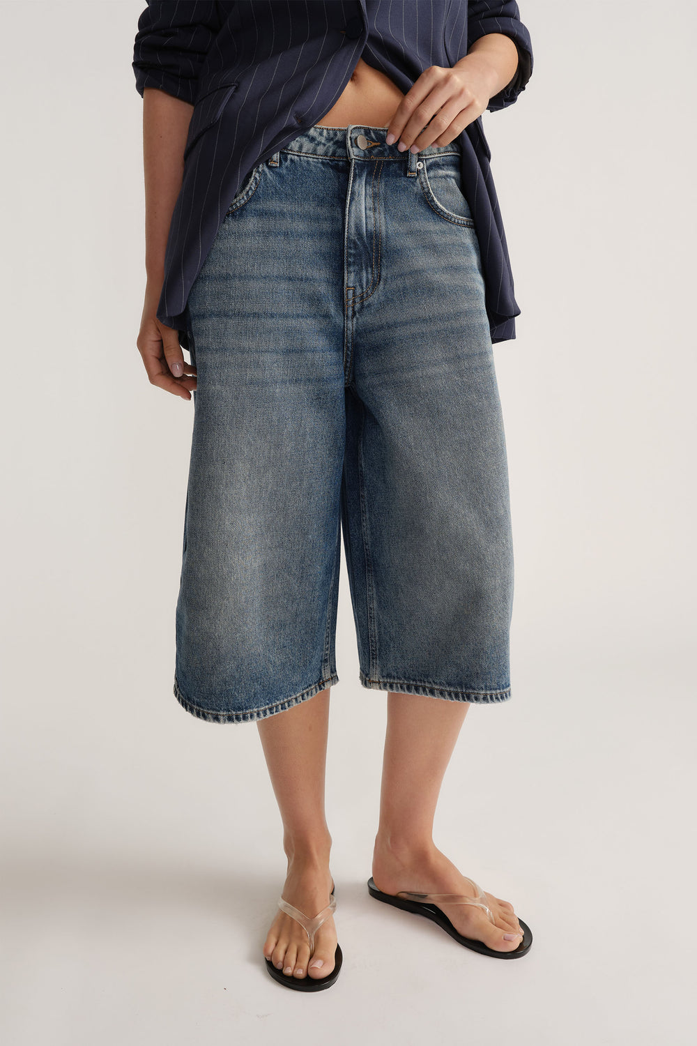 Front view of D-Luxe Denim Long Line Short in mid-blue cotton denim styled with relaxed vibe by Decjuba Australian brand