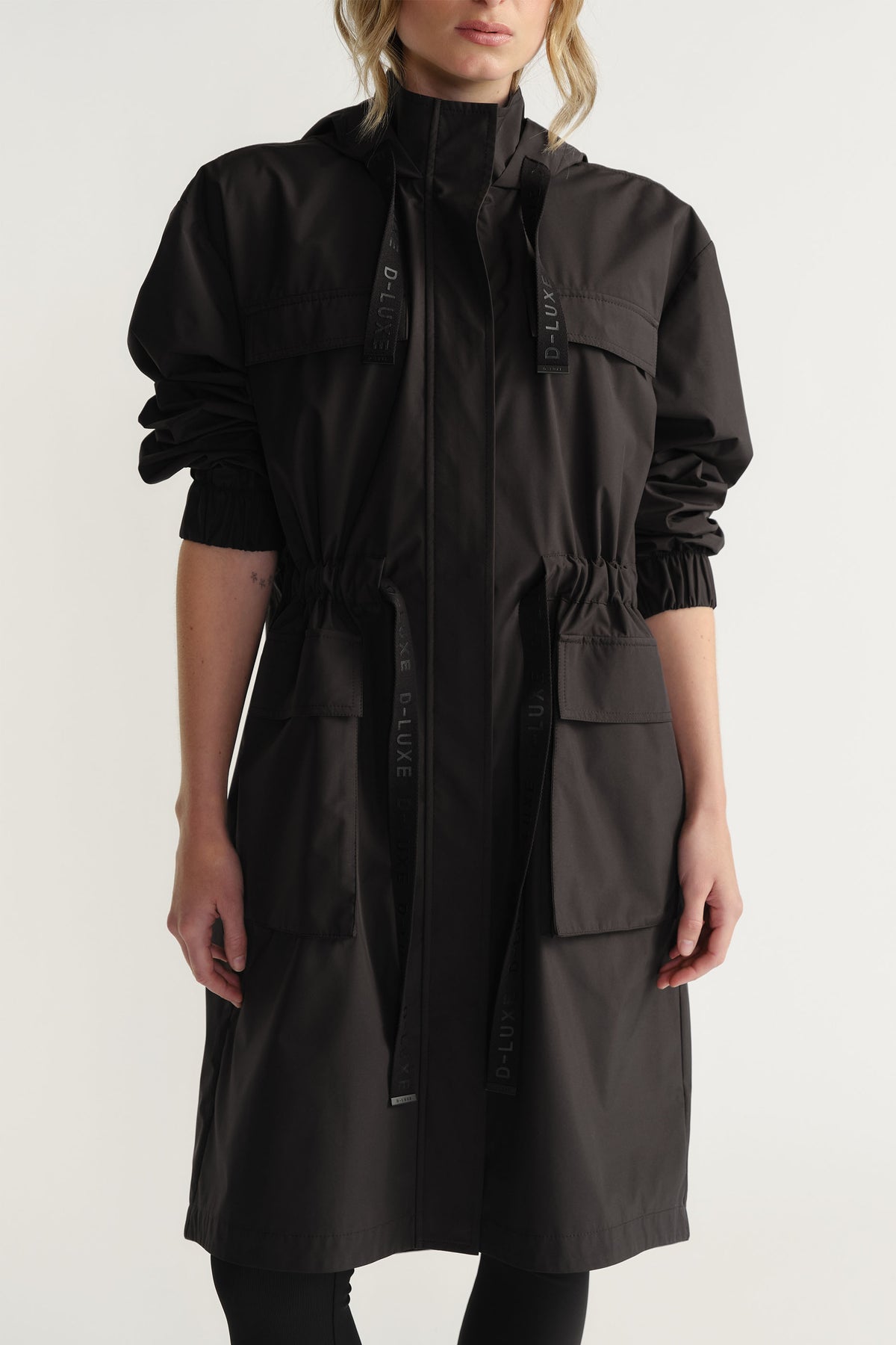 Woman modeling black D-Luxe Rain Jacket with drawstring waist and hood, styled simply by Decjuba Australian fashion brand
