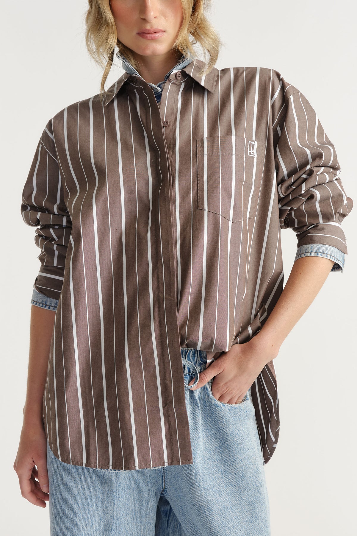 Woman wearing brown and white vertical striped D-Luxe Poplin Stripe Shirt, gallery position 2, paired with light blue denim jeans.