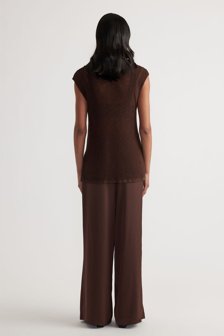 Back view of woman wearing a sleeveless coffee brown knit tank paired with relaxed wide-leg trousers in matching tones