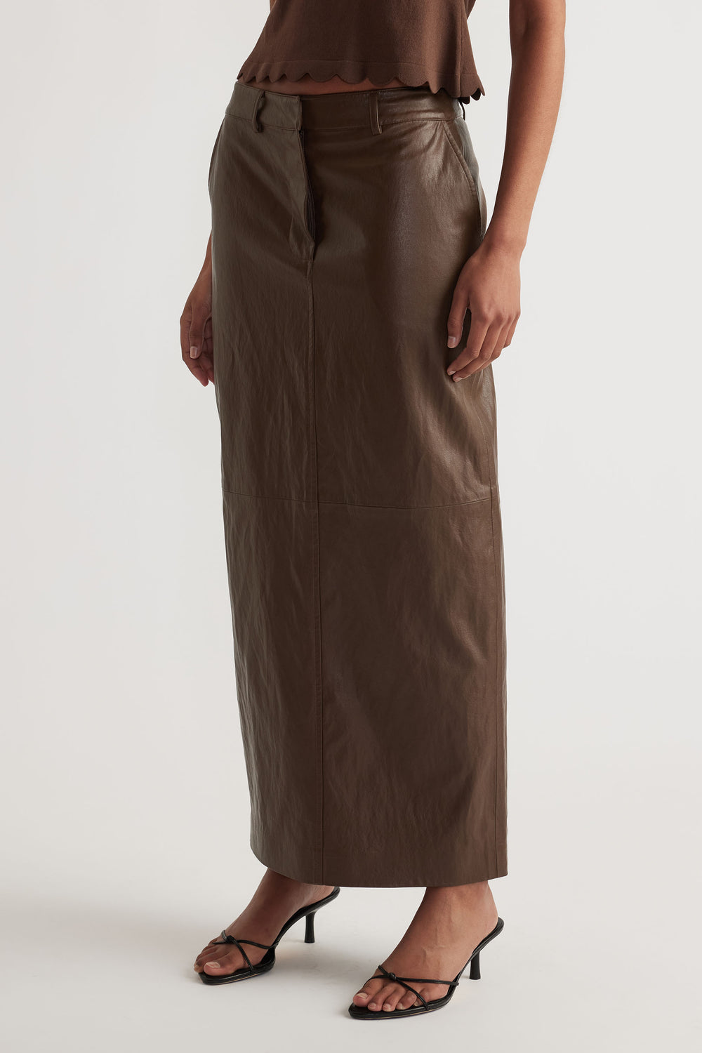Faux Leather Maxi Skirt in rich brown with straight cut, styled with strappy heels for a modern yet versatile look by DECJUBA