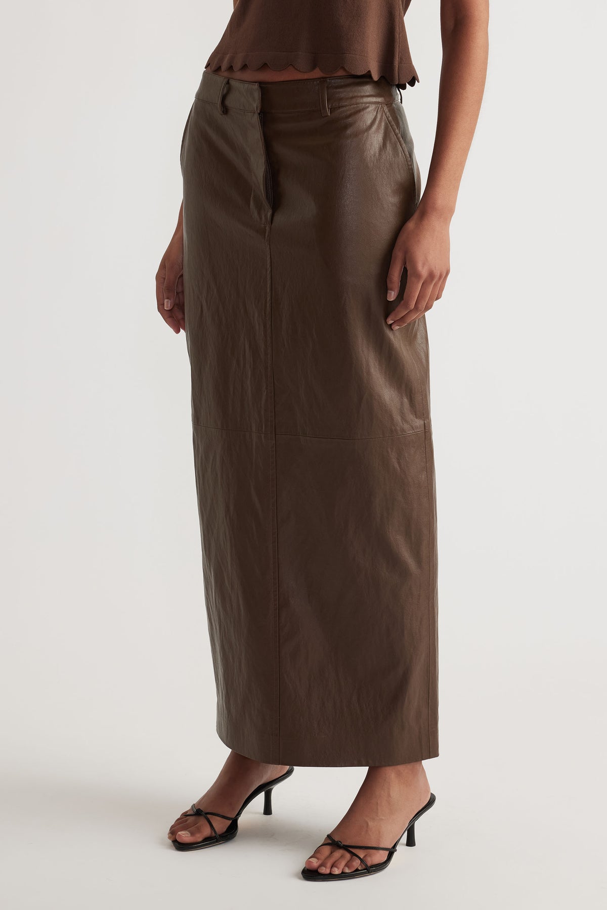 Faux Leather Maxi Skirt in rich brown with straight cut, styled with strappy heels for a modern yet versatile look by DECJUBA