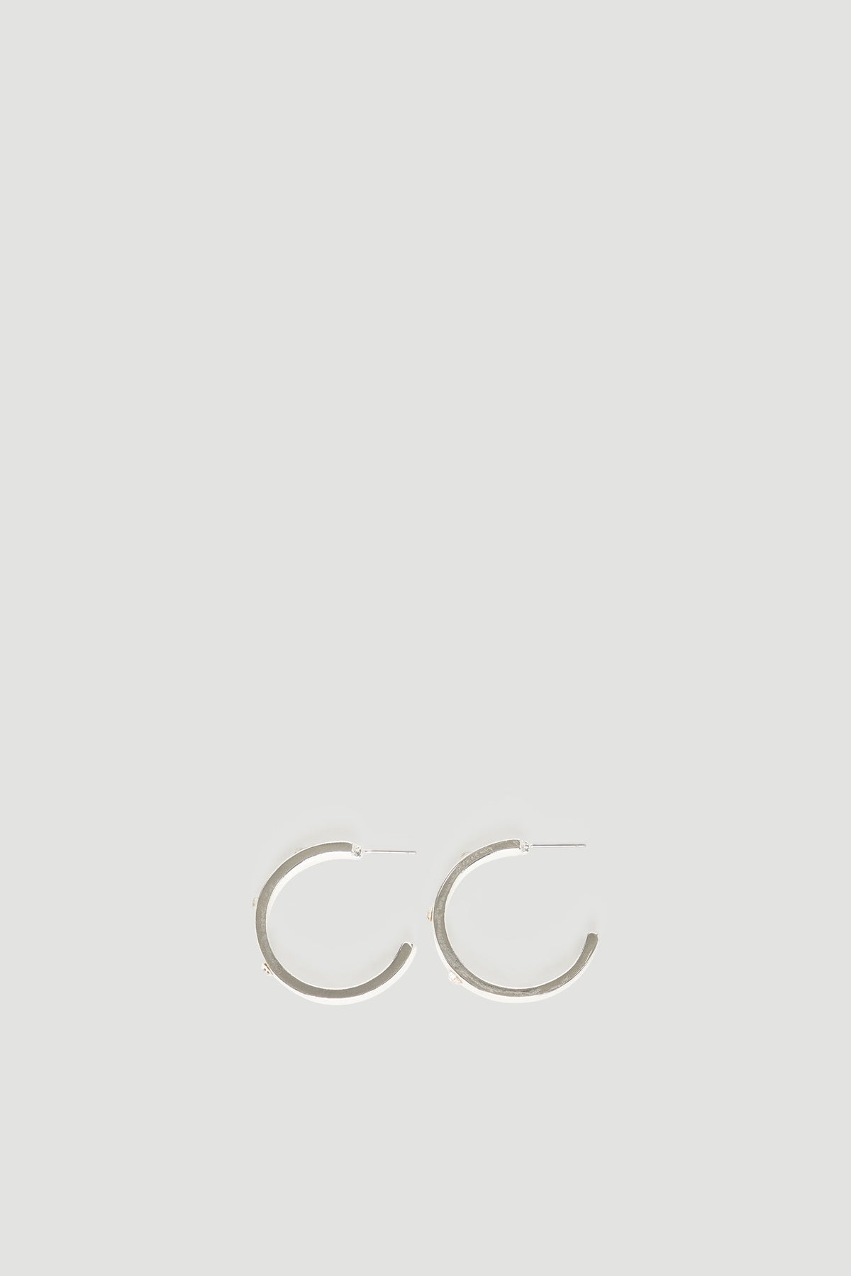 Pair of simple silver hoop earrings with a sleek polished finish against a neutral background
